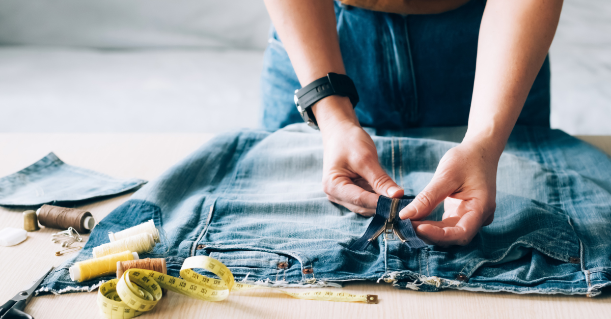 Kvinna byter dragkedja på ett par jeans
